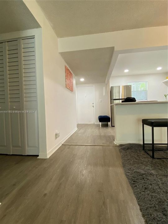 View looking from family room to the kitchen and front door