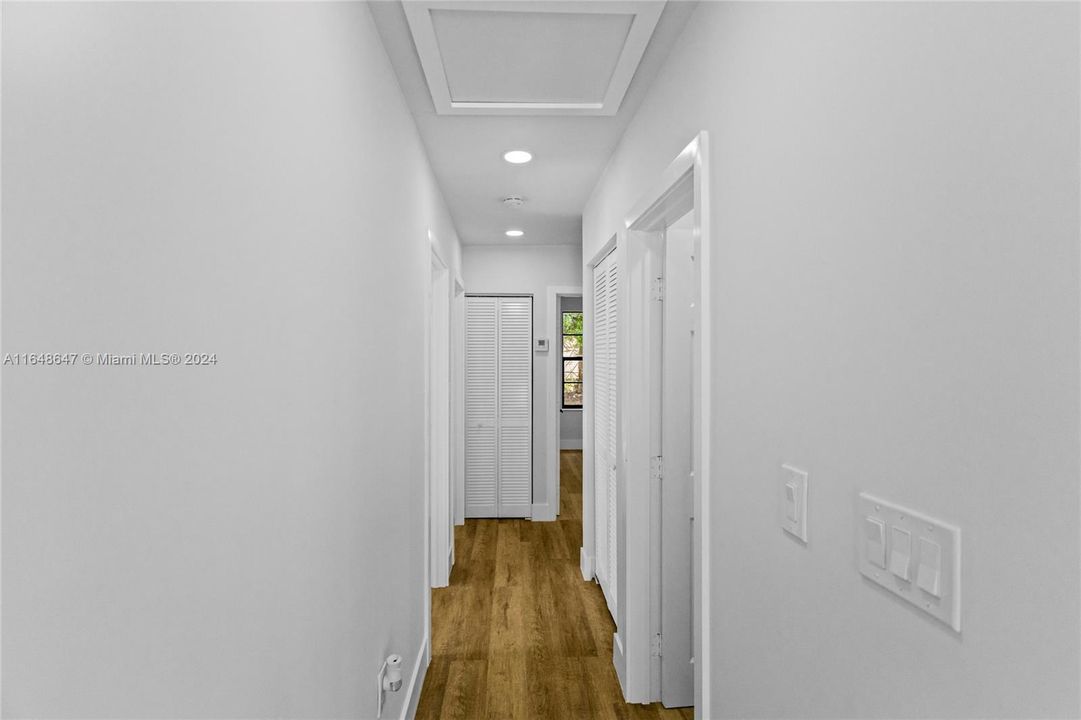 Hallway heading to bedrooms with Bathroom #1 on the right and Bedroom #1 on the first door on the left.