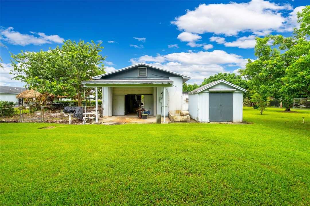 COVERED CARPORT OOFF THE REAR WAREHOUSE W STORAGE SHED