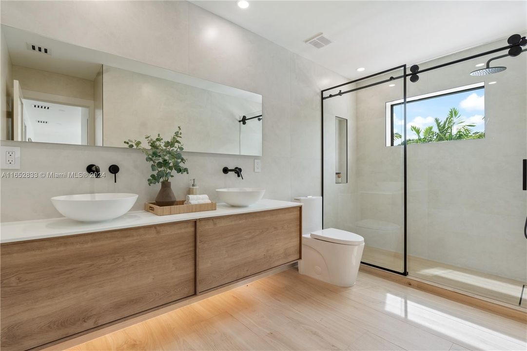 master bathroom on suite custom cabinet with lighted mirror and porcelain stone tiles throughout