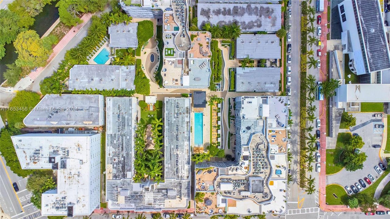 Stunning aerial view showcasing the resort-style building, lush courtyards, and surrounding Miami Beach landmarks.