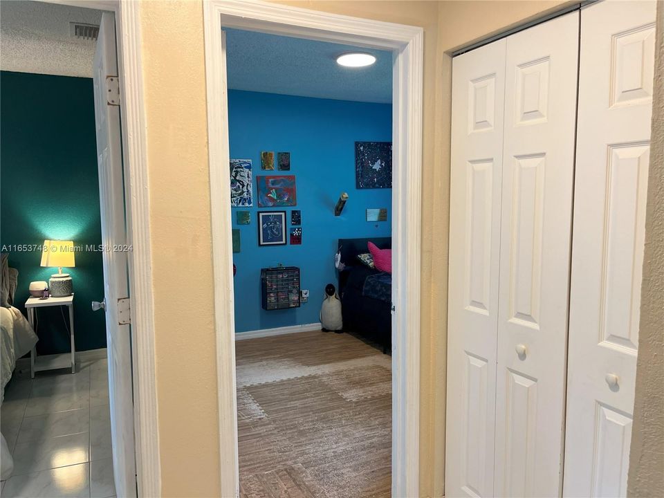 View from hallway into 2 bedrooms, large closet on the right.