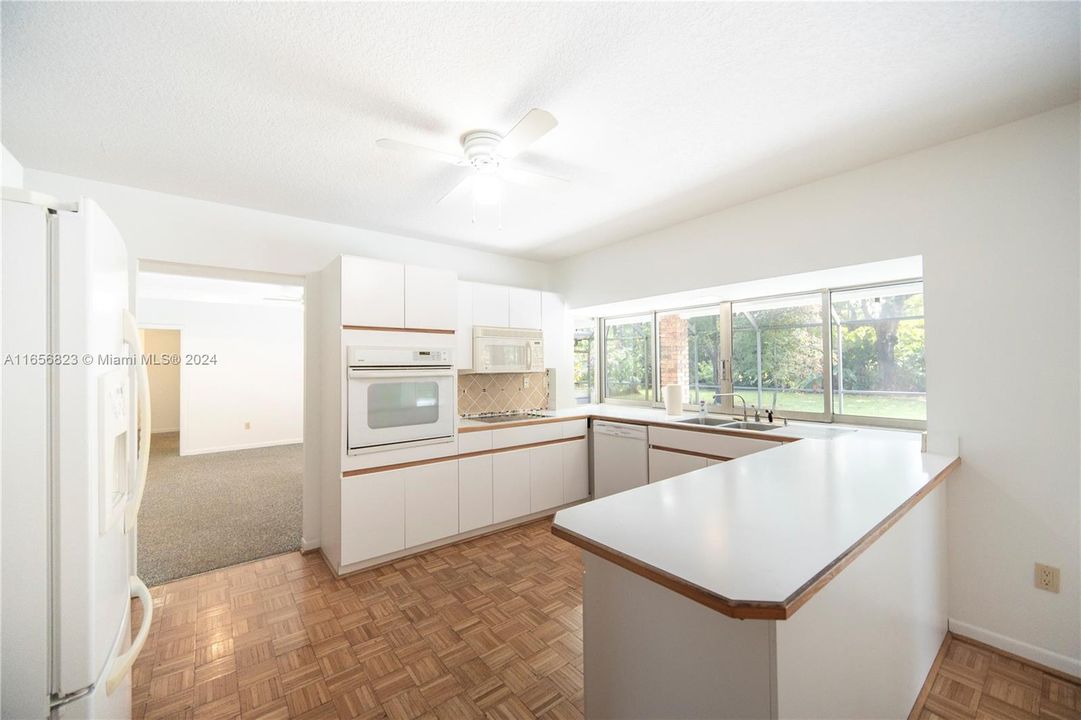 Well- lit kitchen with access to a family room at the rear.