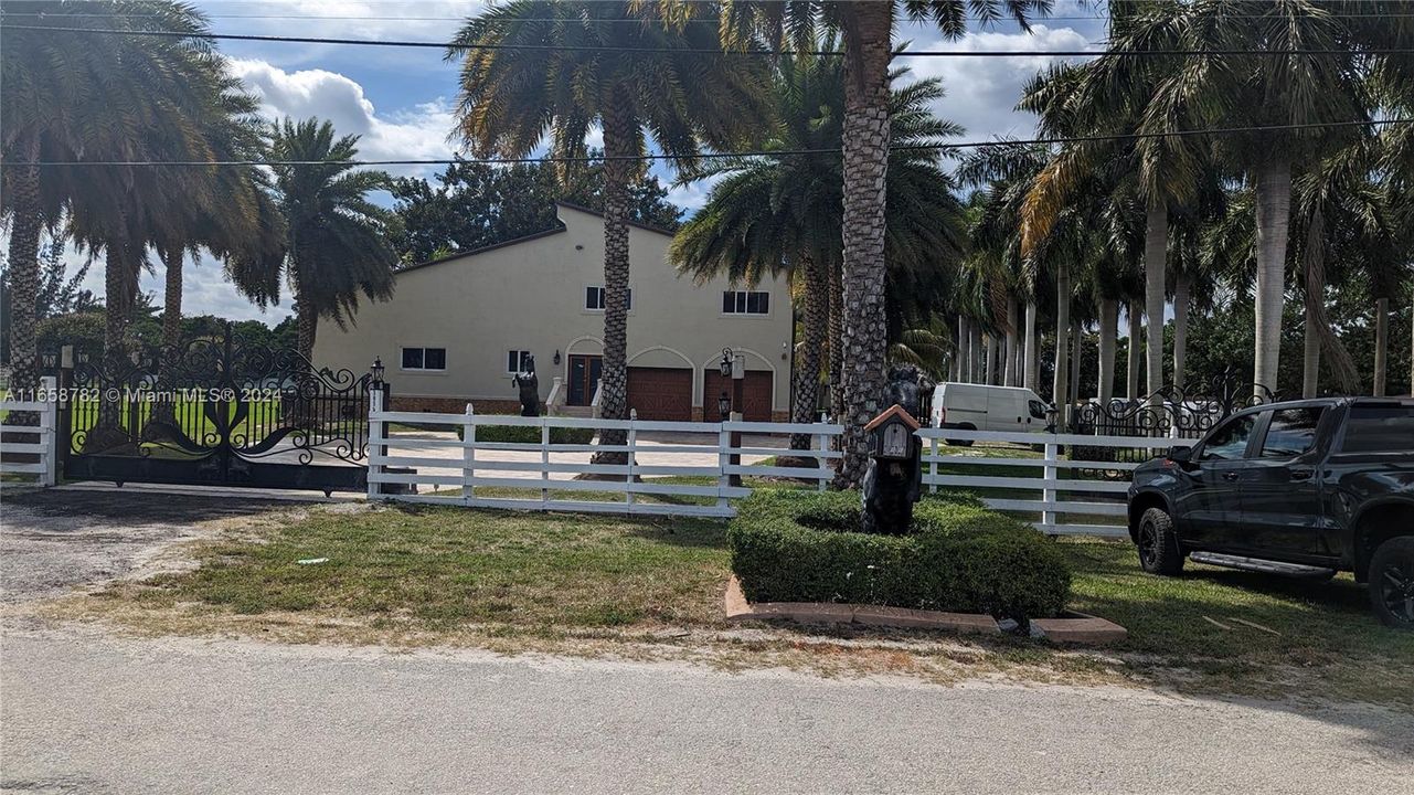 This elegant 6-bedroom, 6-bathroom estate boasts timeless charm with a spacious driveway, nestled on a 2-acre lot in Miramar, offering privacy and expansive outdoor space.