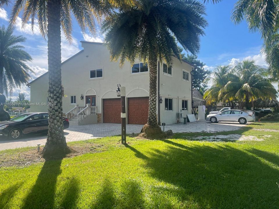 This elegant 6-bedroom, 6-bathroom estate boasts timeless charm with a spacious driveway, nestled on a 2-acre lot in Miramar, offering privacy and expansive outdoor space.