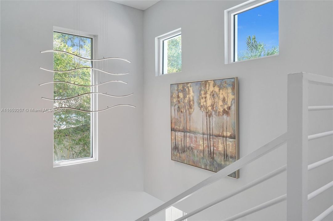 View from second floor of the modern floating-steps stairs. Plenty of natural light with large windows.