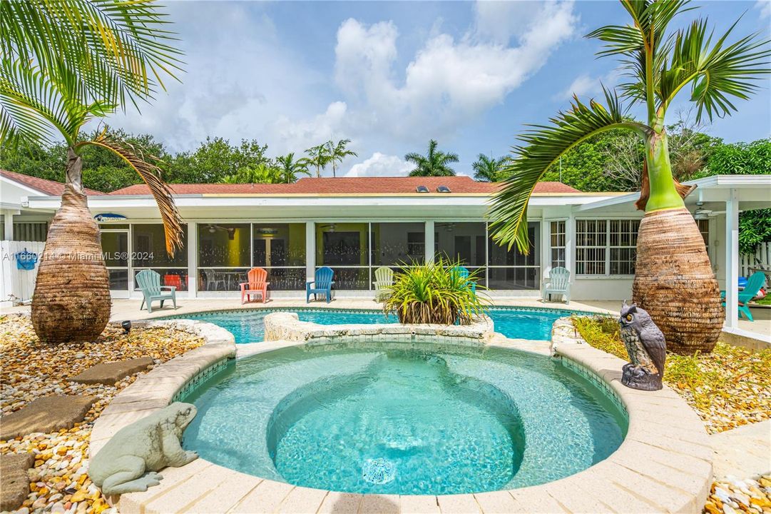 Raised Spa with falls that run into pool.Gorgeous Lushly landscaped neighborhood in Redland 1/3 to 1+ acre estates, she's a 4(5)/3 plus office pool/spa, over 4k square ft., 2 car garage w/ 2 circle driveways. The street is a horse shoe. ideal for walking. buffered  by  groves/farms