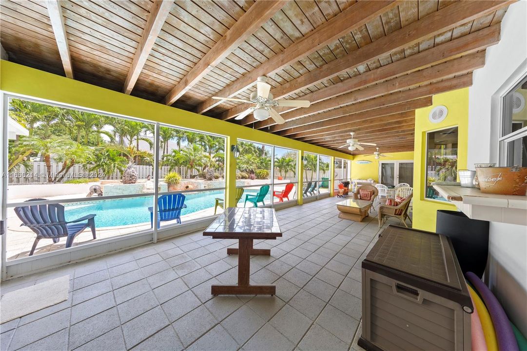 PATIO COVERED & SCREENED W/ T&G CEILINGS ALMOST THE LENGTH OF THE HOUSE. MULTIPLE SETS OF FRENCH DOORS LEAD INTO THE PATIO, ALSO WITH HURRICANE SHUTTERS YOU CAN CLOSE IN THE ENTIRE PATIO