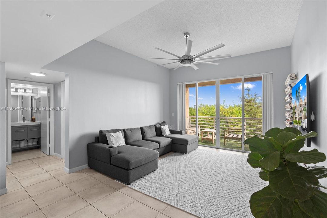 The living room is filled with natural light, highlighting the high ceilings.