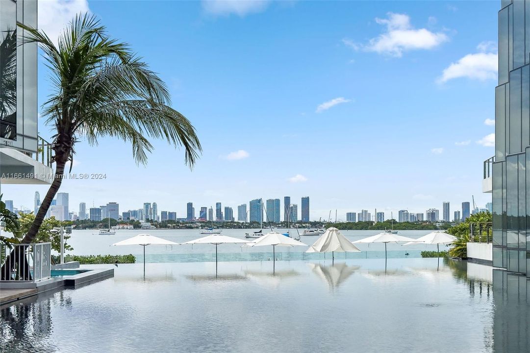 view from sitting area in pond in back of building overlooking pool and Biscayne Bay