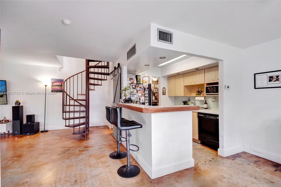 Open floor plan allows the cook to be part of all the action! Spiral staircase and stained concrete floor give the home an edgy, uptown vibe!