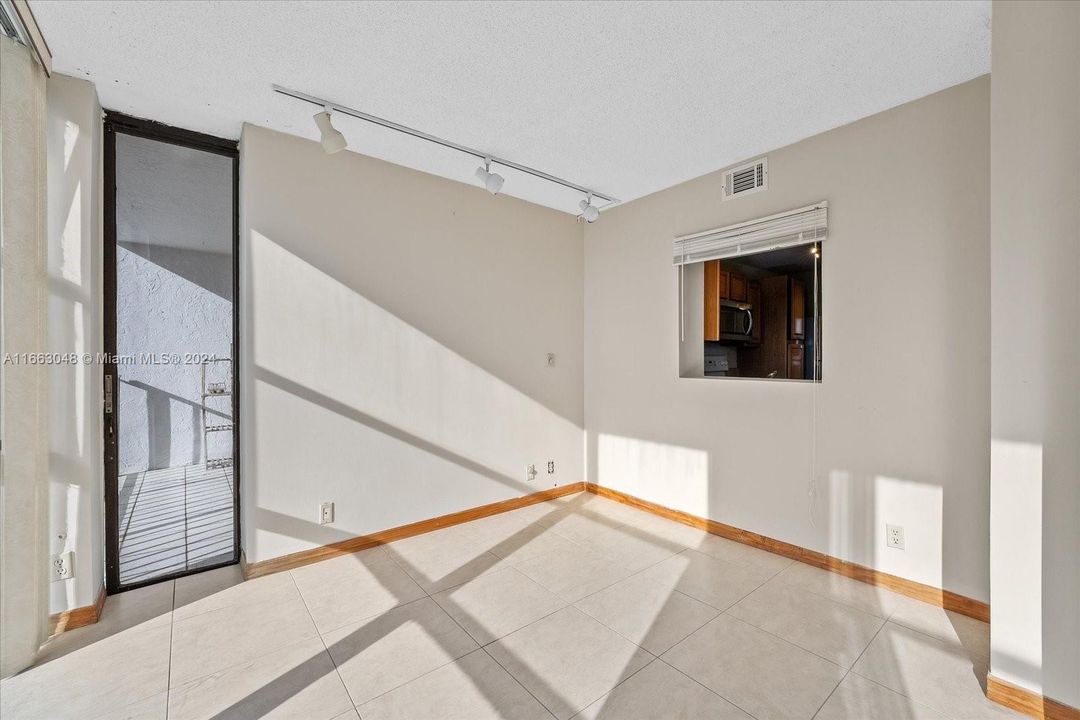 Second Bedroom / Den / Home Office Space with panorama windows, blinds and balcony access.Pass through window to the kitchen.   A great floorplan at 1000 Parkview Drive, Unit #824. Hallandale Beach.