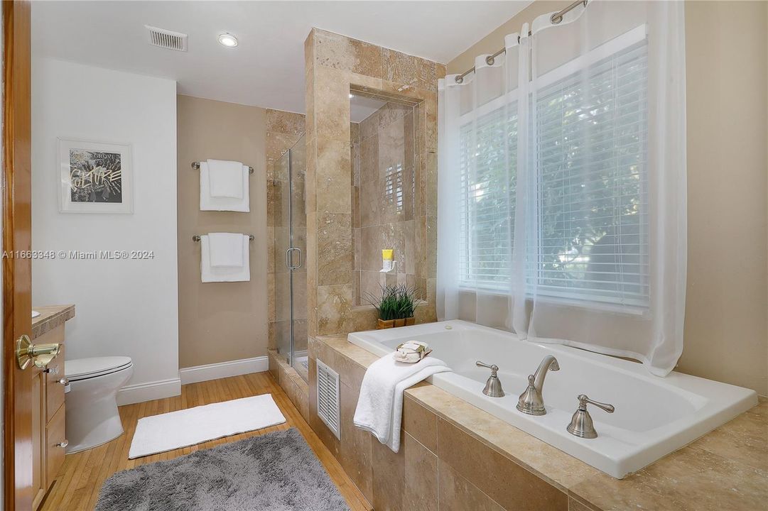 Master Suite Bathroom: jetted hot tub, shower, and window privacy blinds