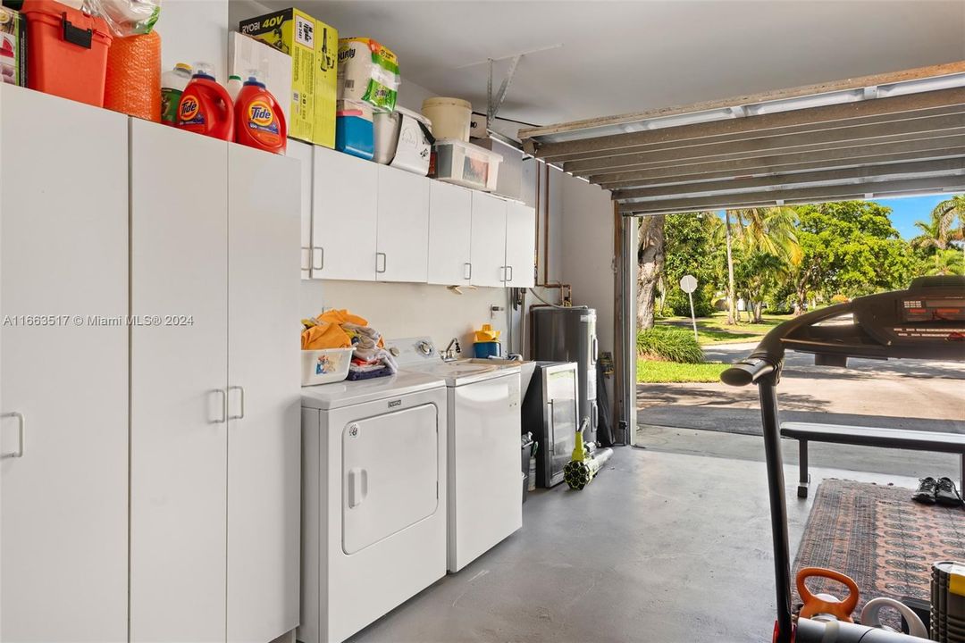 Laundry located in garage with walled A/C unit