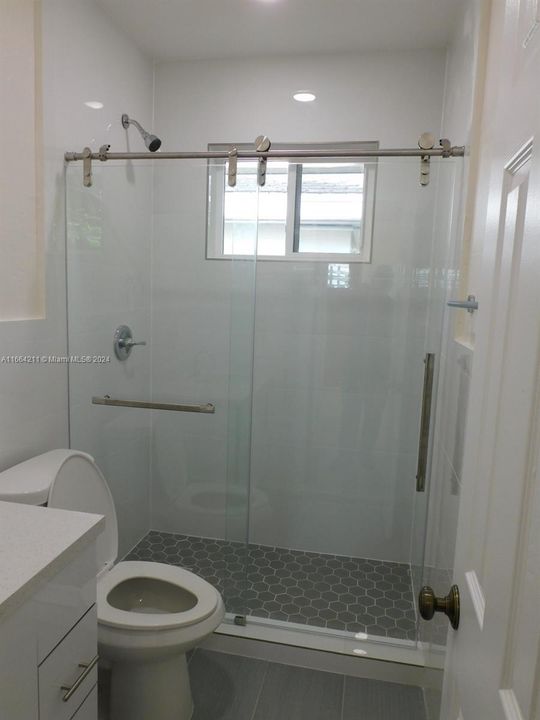 Updated bathroom with glass shower door.