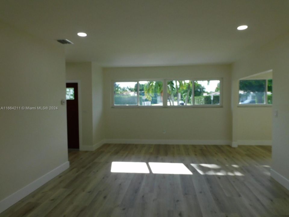 Living room with view to entry way - high windows provide privacy and plenty of natural light.