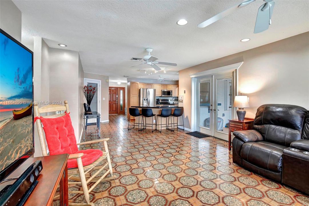 Spacious family room featuring French doors with integrated blinds, offering plenty of natural light and easy access to the backyard. Perfect for entertaining or relaxing!