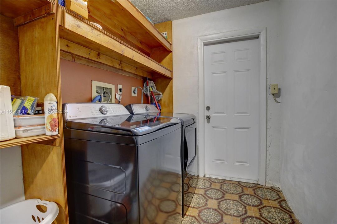 Large laundry room boasts a new washer/dryer and lots of storage space.