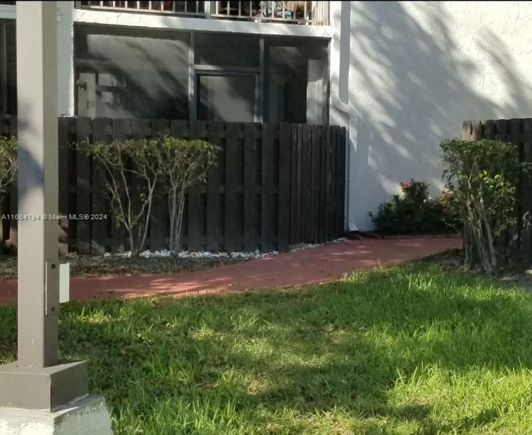 COVERED SCREENED PATIO WITH DOOR ALSO LEADS TO AN OPEN PATIO THAT LEADS TO WOOD ACCESS DOOR WHICH IS STEPS FROM ASSIGNED PARKING SPACE