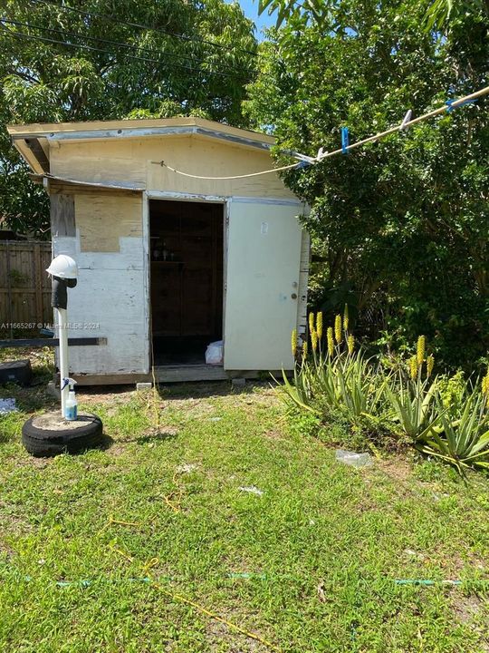 The backyard includes a convenient storage space, perfect for keeping gardening tools, outdoor equipment, or seasonal items neatly organized.