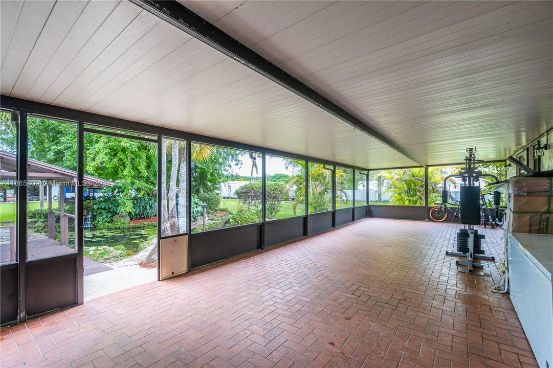 LARGE COVERED PATIO OVERLOOKING THE AMAZING PROPERTY.