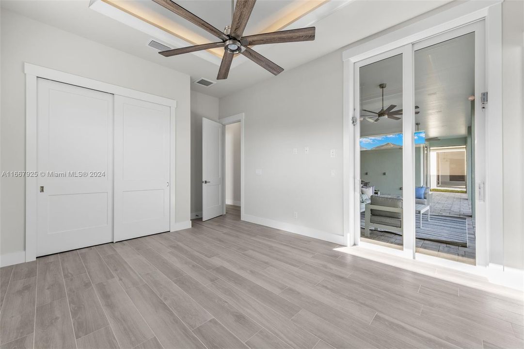 guest bedroom main floor with slider to pool and ensuite/pool bath