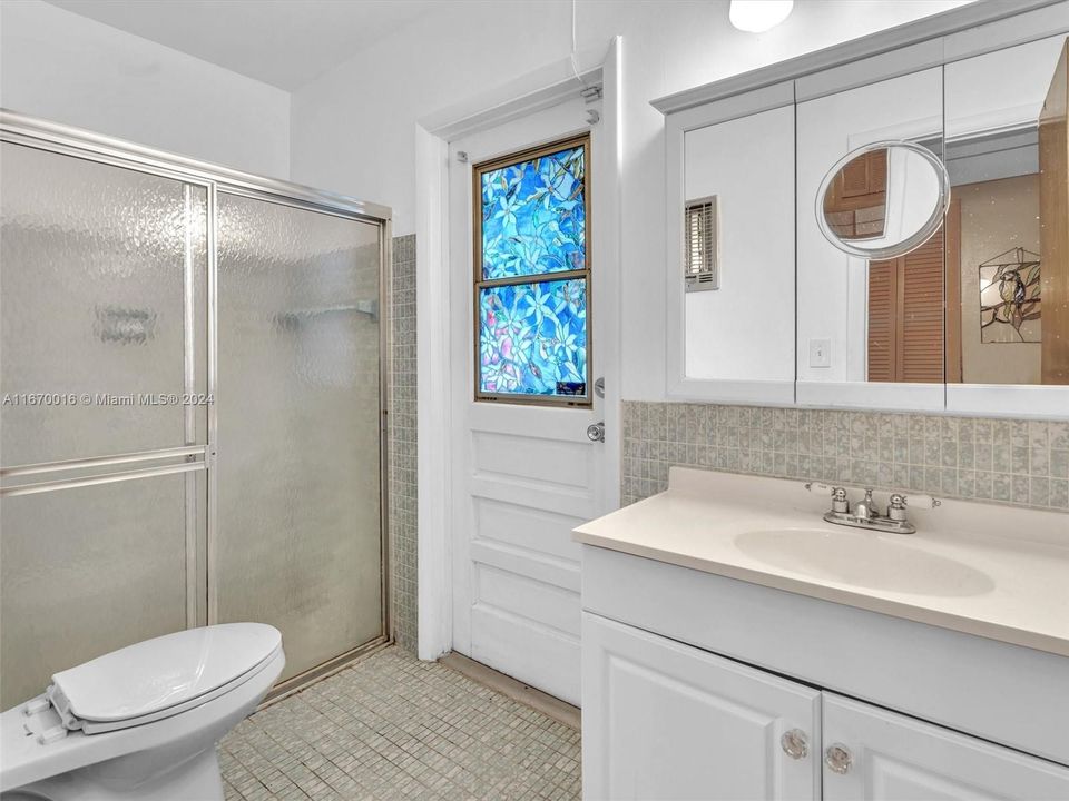 Primary bathroom with a door out to the backyard - perfect if you ever install a pool