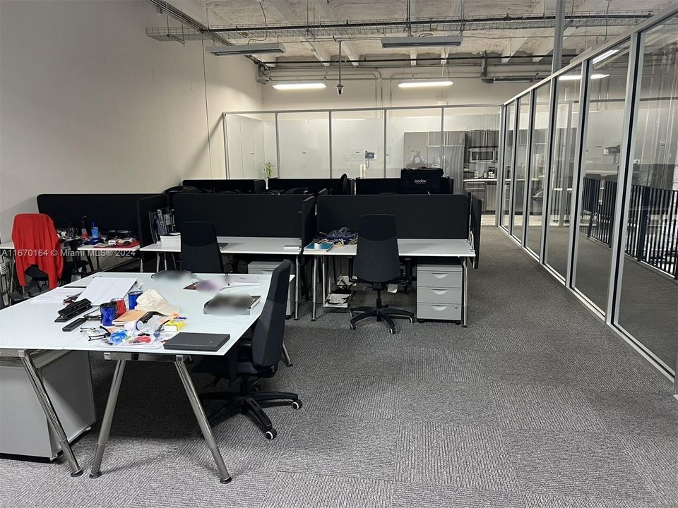 Lower office area looking  out toward spacious reception area from open work area