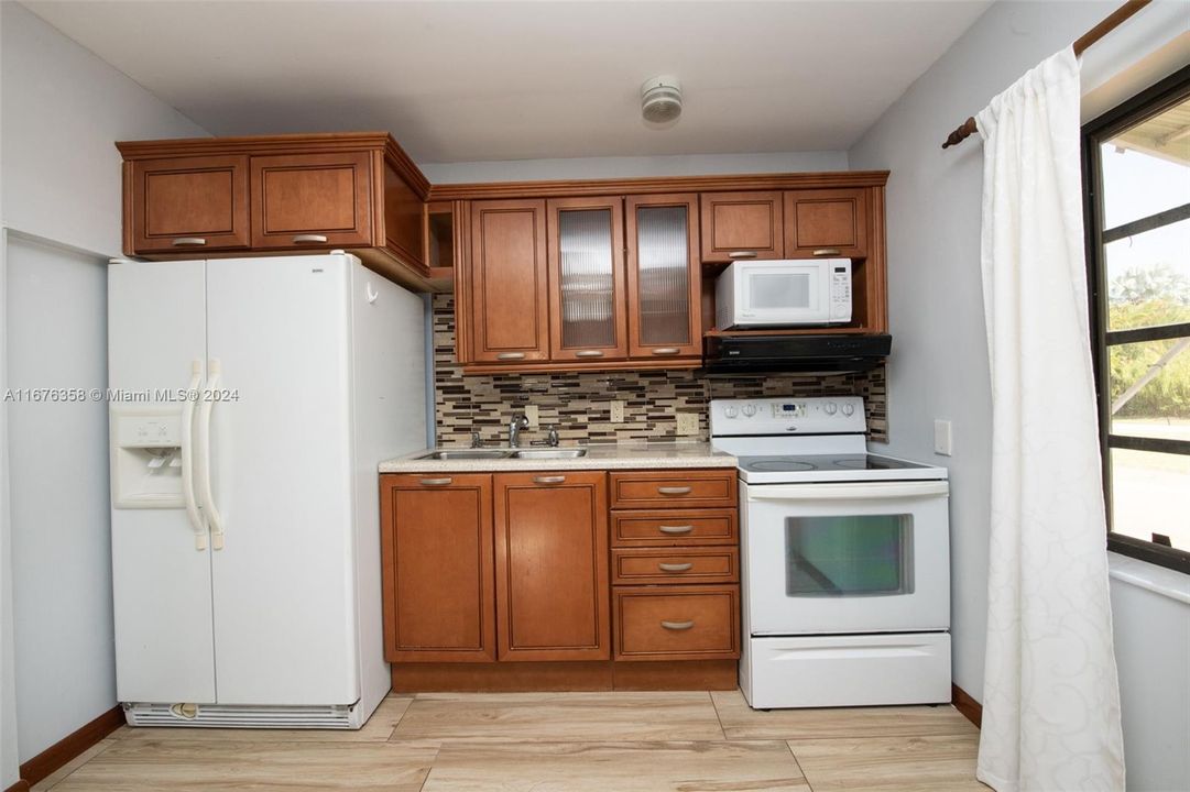 The kitchen has wood cabinets and corian countertop with doble sink, double door refrigerator, range with oven and microwave.