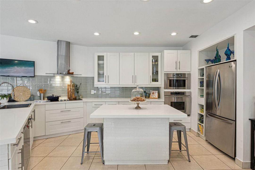 Views of pool patio and tennis court from huge kitchen