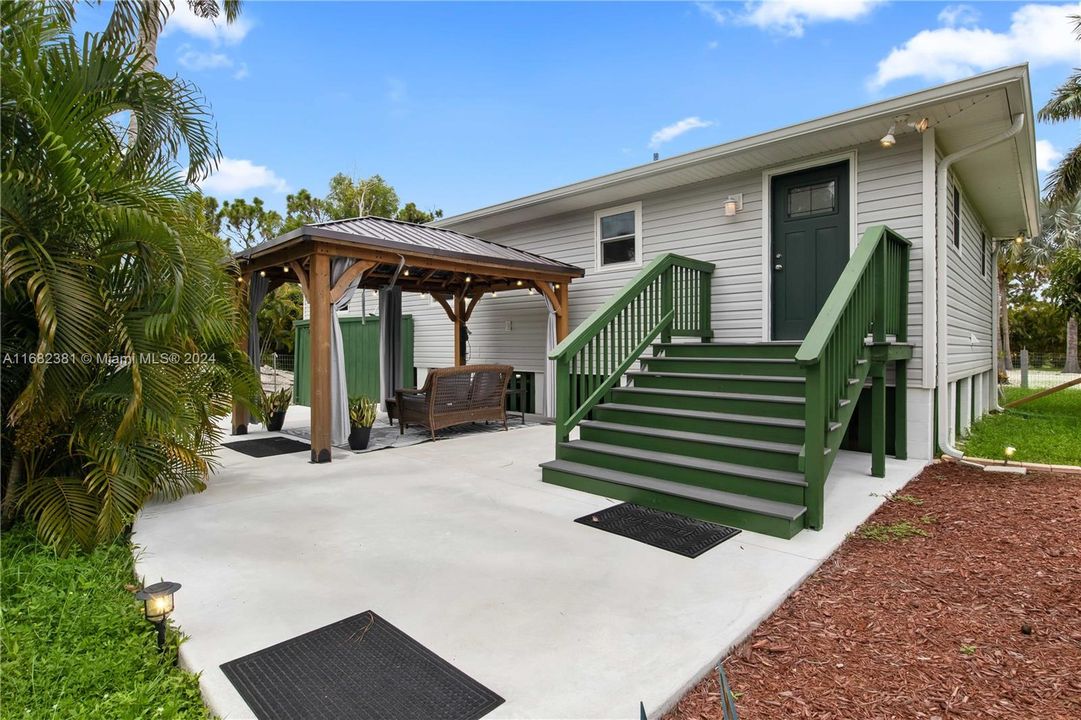 Patio area off the kitchen with a gazebo and outdoor shower