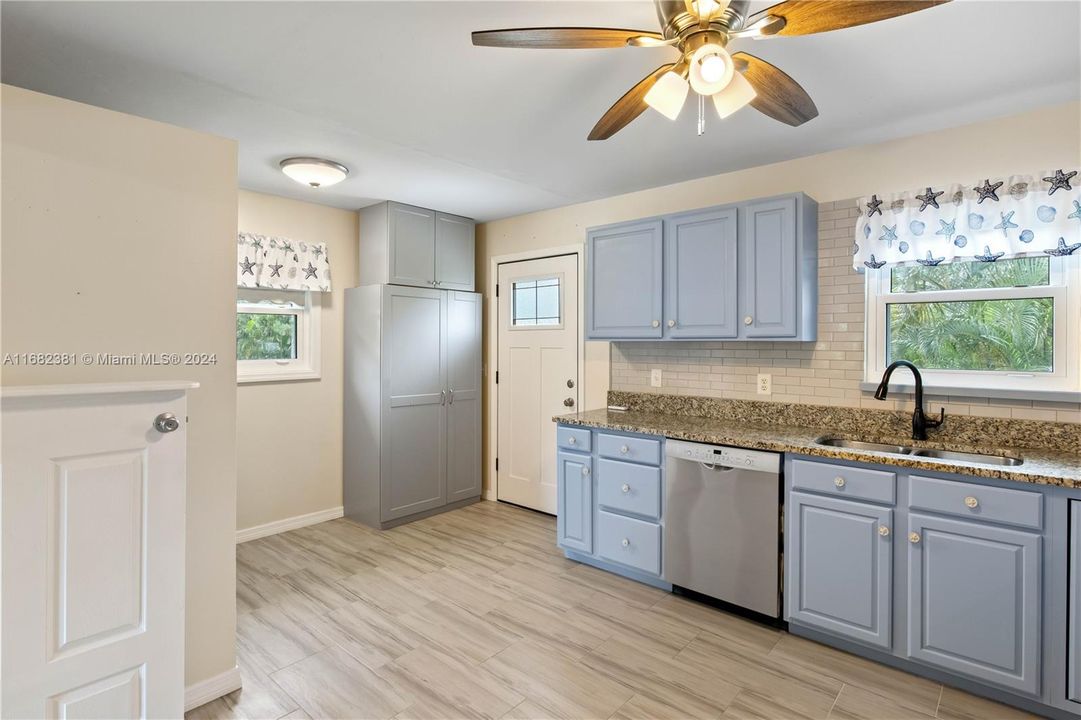 Kitchen with extra cabinets for storage and a door leading to the back patio.