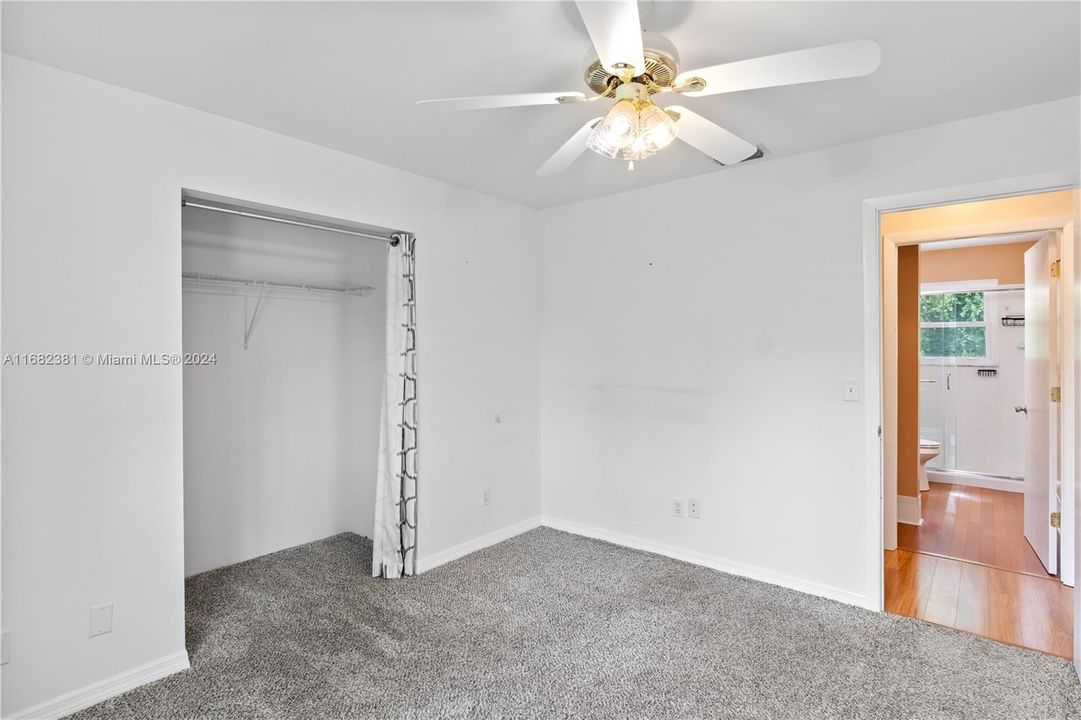 Carpeted bedroom with ceiling fan