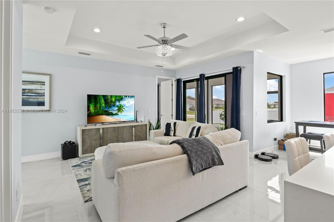 Living room with a raised ceiling and ceiling fan