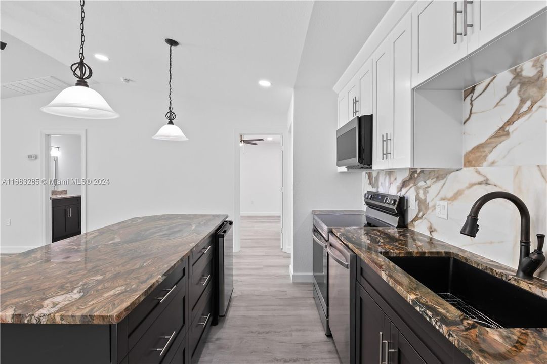 Close up of the luxury countertops and backsplash! Beverage bar is perfect for wine and this is the perfect layout for entertaining!