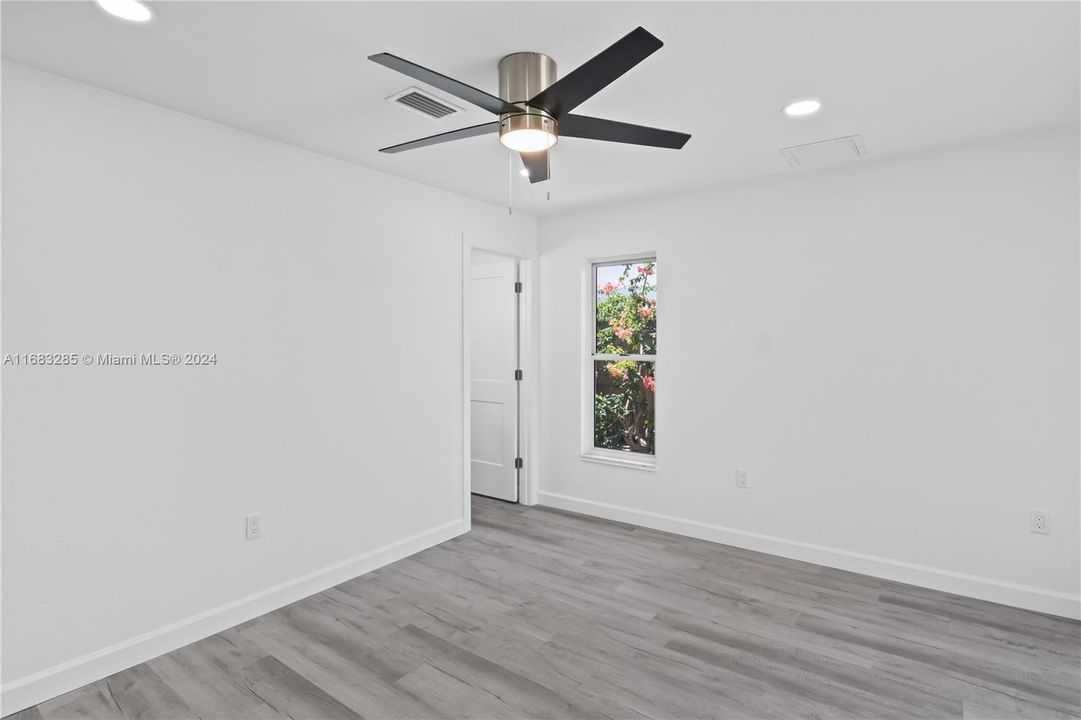 Generous size guest bedroom with new flooring, baseboards, lighting, paint and ceiling fan!