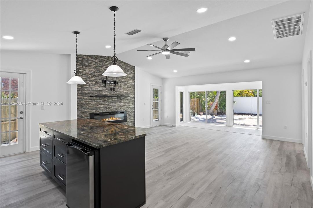 Custom cabinets with pull out soft close drawers - not only a beautiful kitchen island but also very functional! Check out the extension of the great room - the back room runs the full length of the great room and has a wall of sliders to allow the beauty of the outside and the natural light in!...