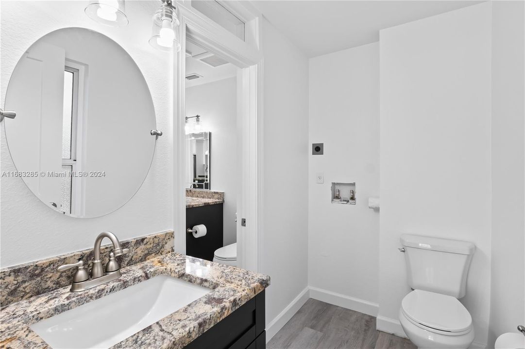 Second bathroom with washer and dryer stackable access.