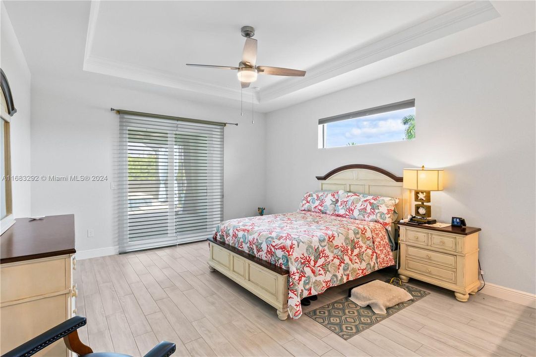 Master bedroom is a true suite. Again, it’s all of the details look at the coffered ceilings, the sliders out to the pool, the transom window, and a large size of the bedroom. It is split from the other bedrooms for maximum privacy.