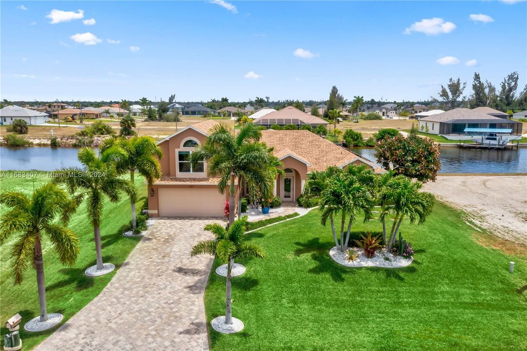 View of front facade with a garage, a water view, and a front lawn