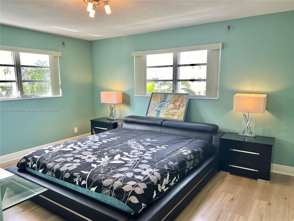 Large oversized primary bedroom with 3 custom built-in walk-in closets, updated ensuite and double window exposure. Windows overlook the beautiful coutryard. Hurrican shutters.