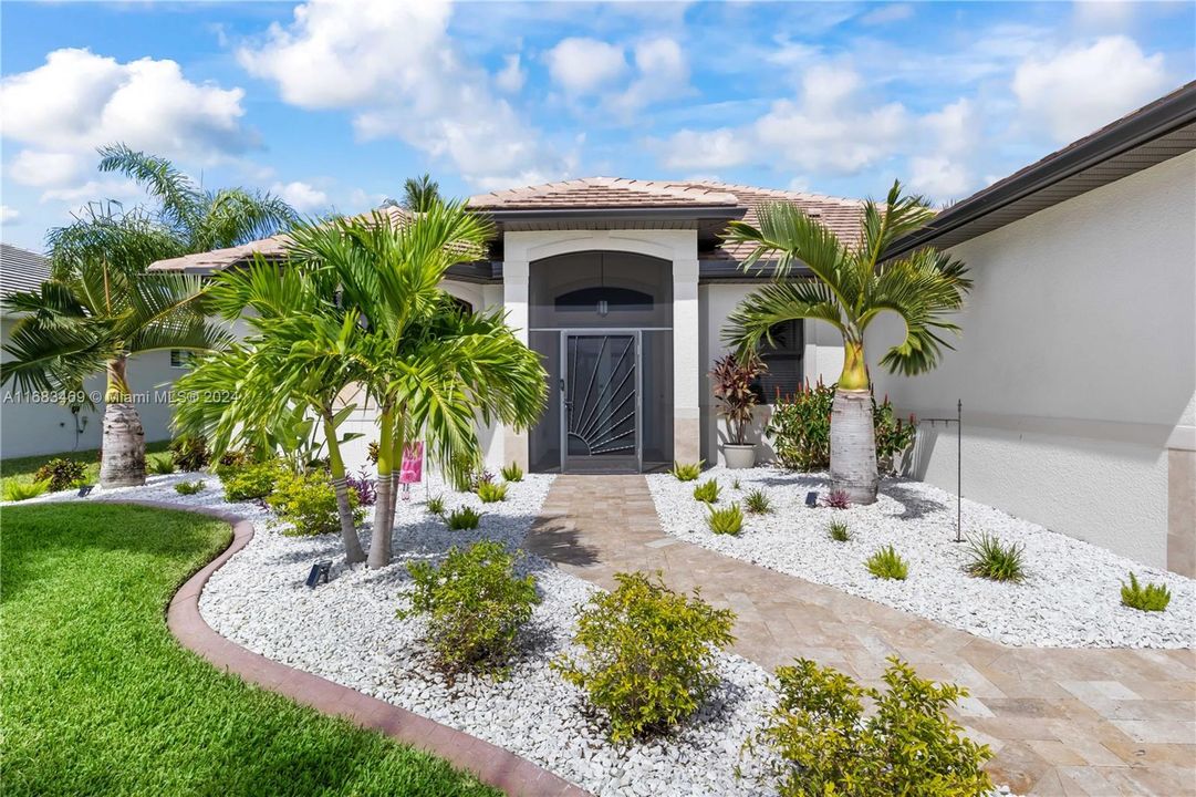 Not just your average property! Beautiful travertine walkway, lush tropical landscaping with curbs - this will WOWZA you. Screened front patio to allow for opening the doors and enjoying the cool breeze during the winter months!