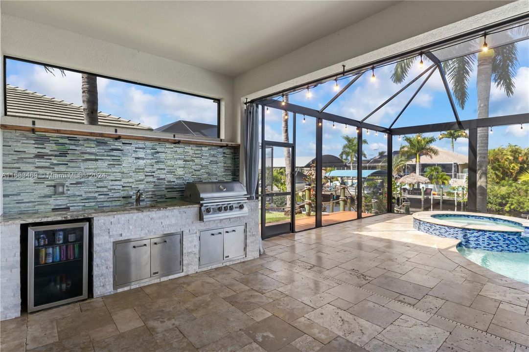 Close up view of the outdoor kitchen station as well as the hop scotch travertine tile on the patio!