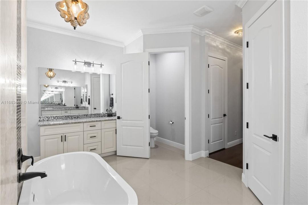 Primary bathroom with his and hers vanities, soaking tun and a private water closet.