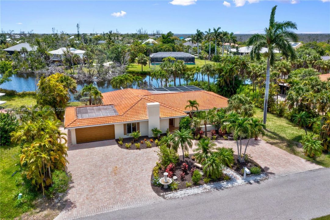 Picture perfect! Overhead view of the home and gardens with the lake and lush landscaping.