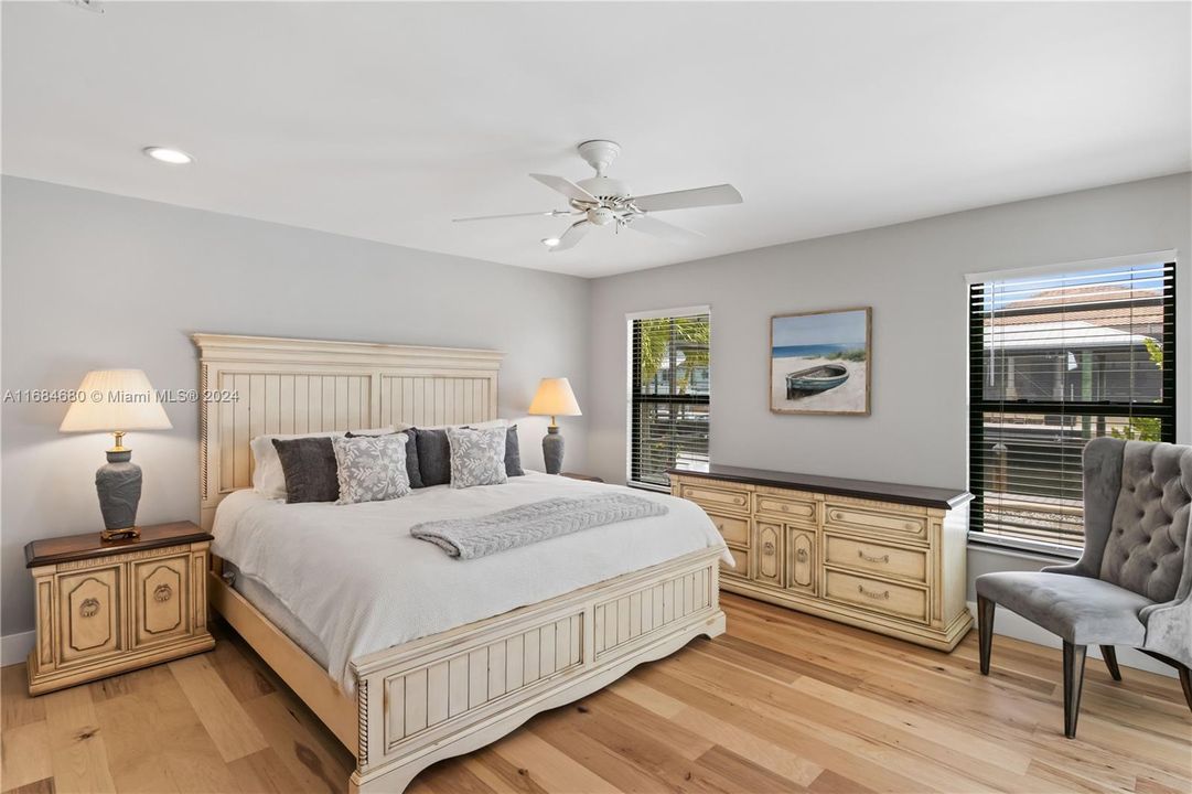 Primary Bedroom featuring light hardwood / wood-style flooring a, abundant light and sliders to the outdoor pool area!