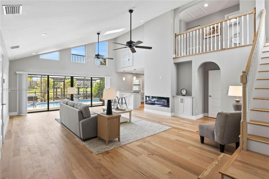 HUUUUUGE Living room with high vaulted ceilings, a wall of sliders and lots of natural light throughout! Total care and top upgrades were used when remodeling this beauty and it is apparent everywhere!