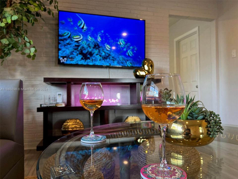 Relax with your favorite drink watching the wall mounted 55" Smart TV in the spacious living room