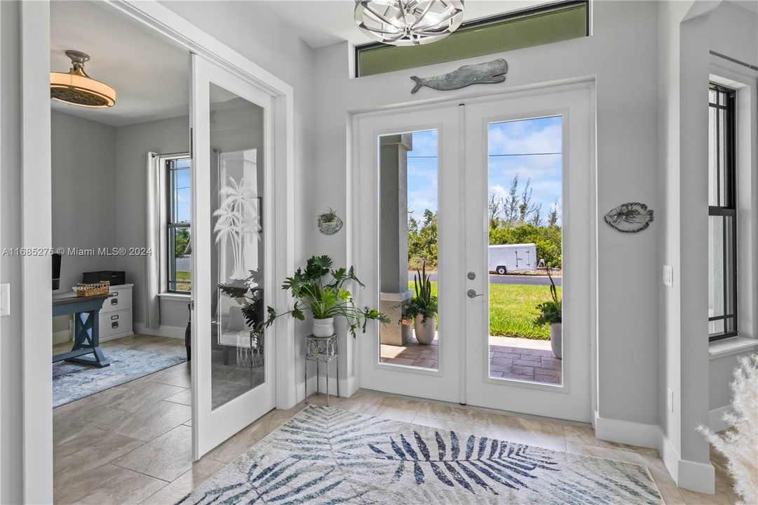 Foyer entrance with plenty of natural light, french doors, and light tile flooring - welcomes you into the flexible floor plan!