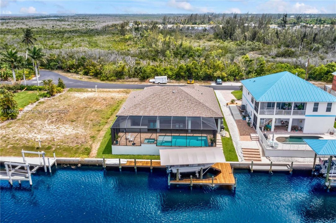 Back of property with pool and dock view.